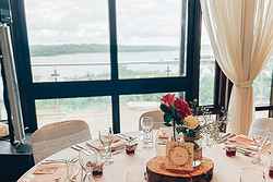 Lake views from the Burrator Room. There is a table laid for a three course meal with flowers in the centre.